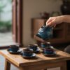 Cận cảnh bộ ấm trà gốm men lam ngọc trên bàn gỗ...