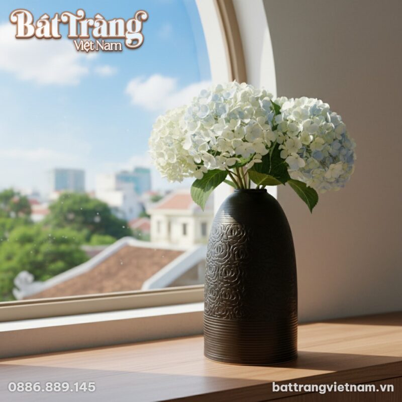 Lọ hoa gốm đặt bên cạnh cửa sổ, bên ngoài là bầ...