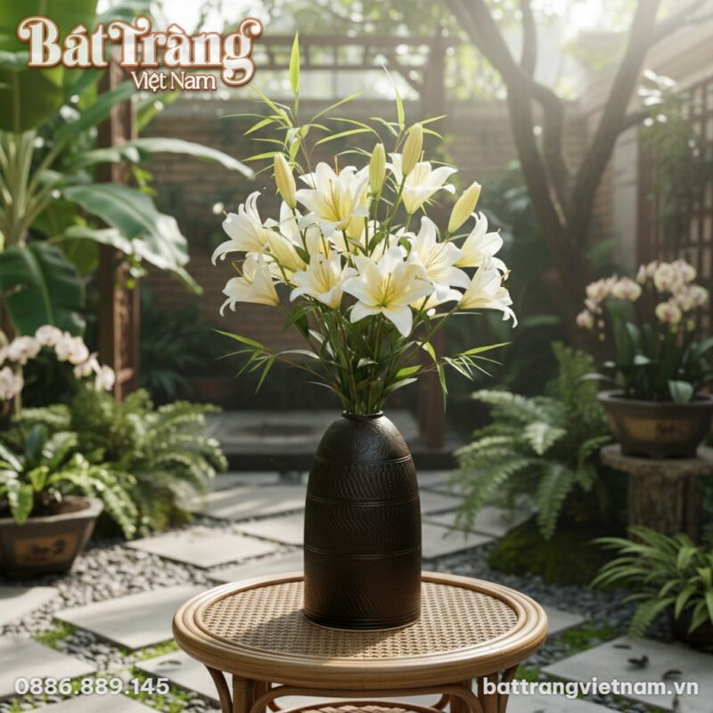 Lọ hoa gốm đặt trên bàn mây ở khu vườn. Trong l...